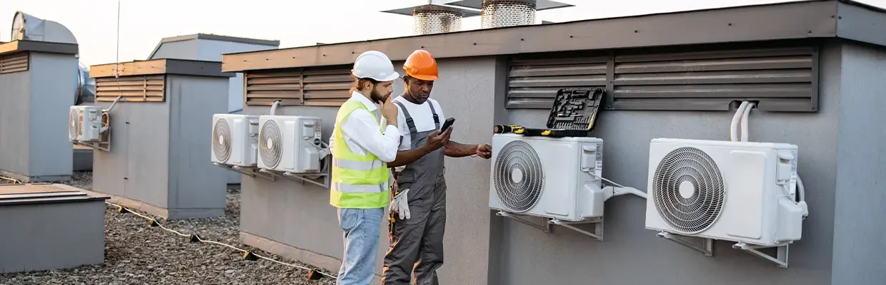 Commercial HVAC technician inspecting rooftop air conditioning equipment